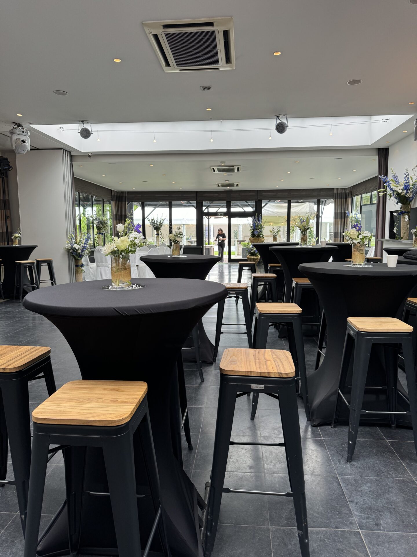 een zaal met ronde staantafels