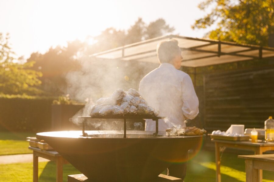 Een chef die in de dalende zon aan het bakken is, buiten op een ofyr